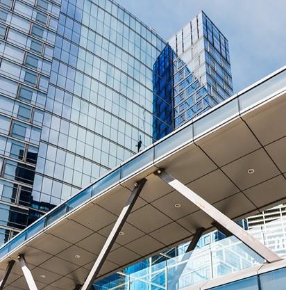 Moderno edificio per uffici dal design angolare, con eleganti pannelli di vetro riflettenti sotto un cielo limpido.